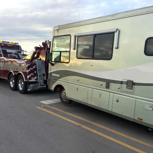 Red-and-grey-heavy-duty-tow-truck-towing-an-RV-in-San-Antonio-TX